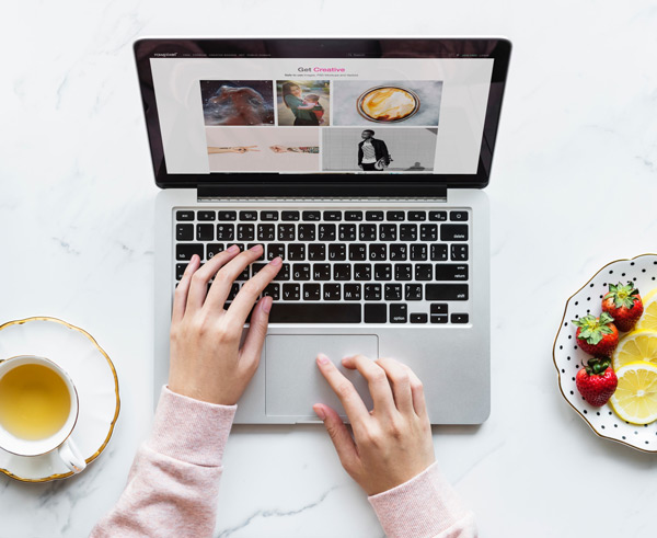 woman using macbook to search for photos with tea by her side. 3 digital marketing myths - debunked with future access